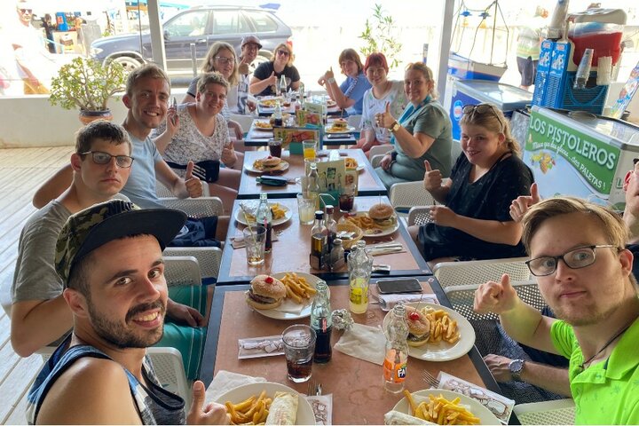 Ibiza - Groepsfoto tijdens eten - Buitenhof Reizen begeleide vakanties voor mensen met een verstandelijke beperking.