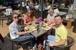 Buitenhof Reizen - Texel - begeleide vakanties voor mensen met een beperking - Blije reizigers op een terras met eten