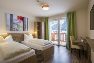 Buitenhof Reizen - Begeleide groepsreizen voor mensen met een verstandelijke beperking - Wintersport Dachstein - Cooee alpin Dachtstein hotel slaapkamer