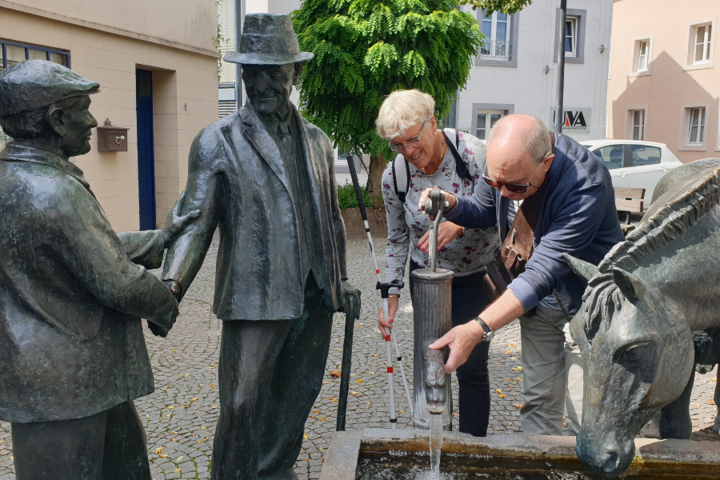 Buitenhof Reizen - Neuerburg in de Eifel - begeleide vakanties voor mensen met een beperking - Reizigers bij standbeeld
