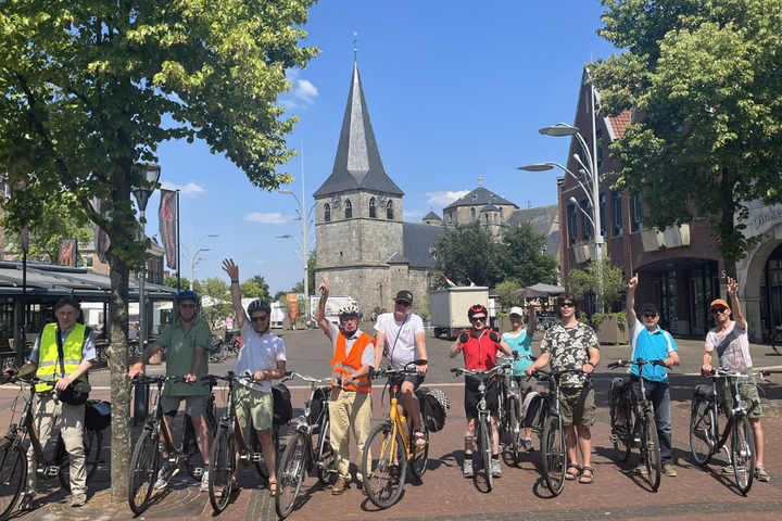 Buitenhof Reizen - Fietsen in Twente - begeleide vakanties voor mensen met een beperking -Reizigers op een rij voor een kerk