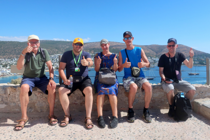 Buitenhof Reizen - Bodrum - begeleide vakanties voor mensen met een beperking - Blije reizigers op een rij met uitzicht op zee