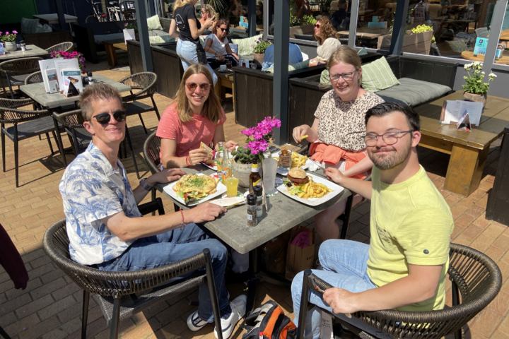 Buitenhof Reizen - Texel - begeleide vakanties voor mensen met een beperking - Blije reizigers op een terras met eten