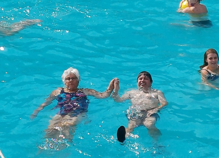 Buitenhof Reizen voor mensen met een verstandelijke beperking - Rustig Aan - Groen en natuur op Corfu - mensen hand in hand liggend in het zwembad