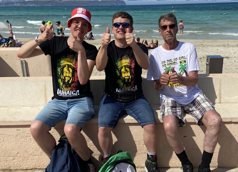 Buitenhof Reizen voor mensen met een verstandelijke beperking - Ondernemend - Zon, zee, strand op Mallorca - Drie reizigers op een bankje voor het strand