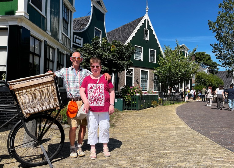 Buitenhof Reizen - Begeleide groepsreizen voor mensen met een verstandelijke beperking - Volendam - twee reizigers met fiets en typisch houten huisje