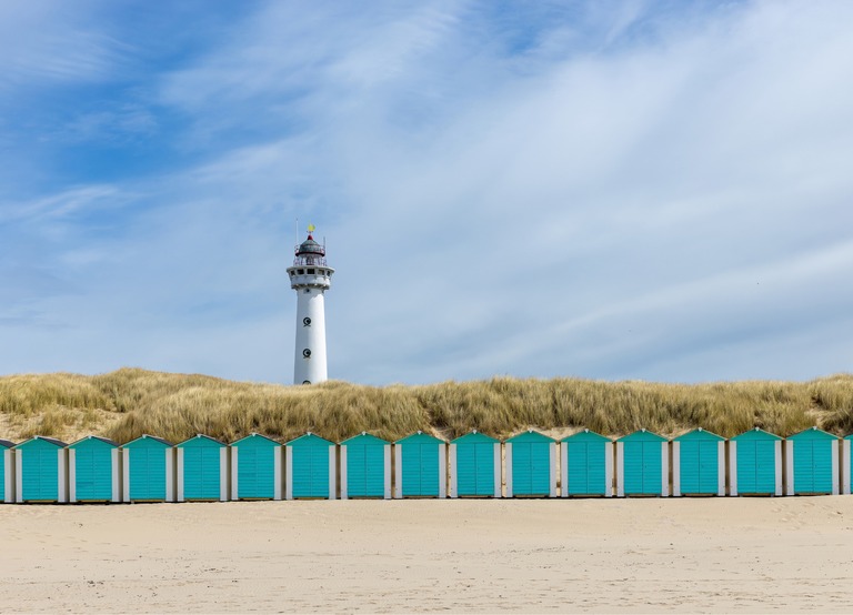 Buitenhof Reizen - Begeleide groepsreizen voor mensen met een verstandelijke beperking - Egmond aan Zee - strand met huisjes en vuurtoren